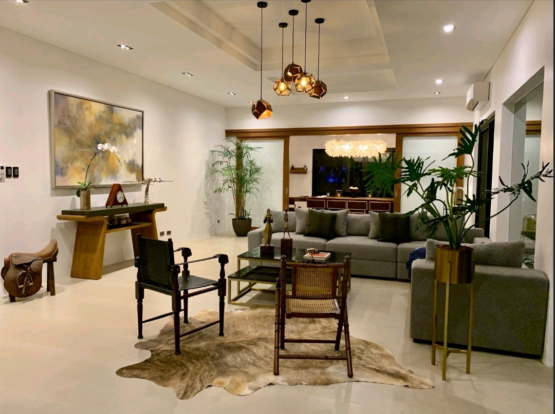 Great room with cowhide rug, timber console and pendant cluster opening to the dining pavilion