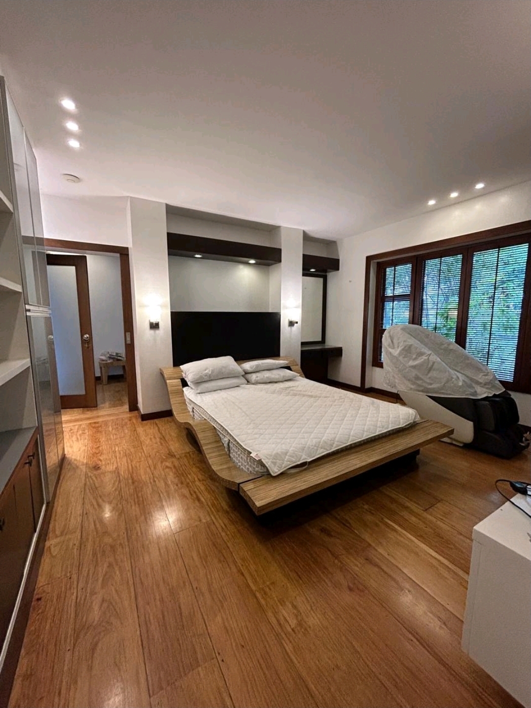 Bedroom with hardwood floors, platform bed and garden windows