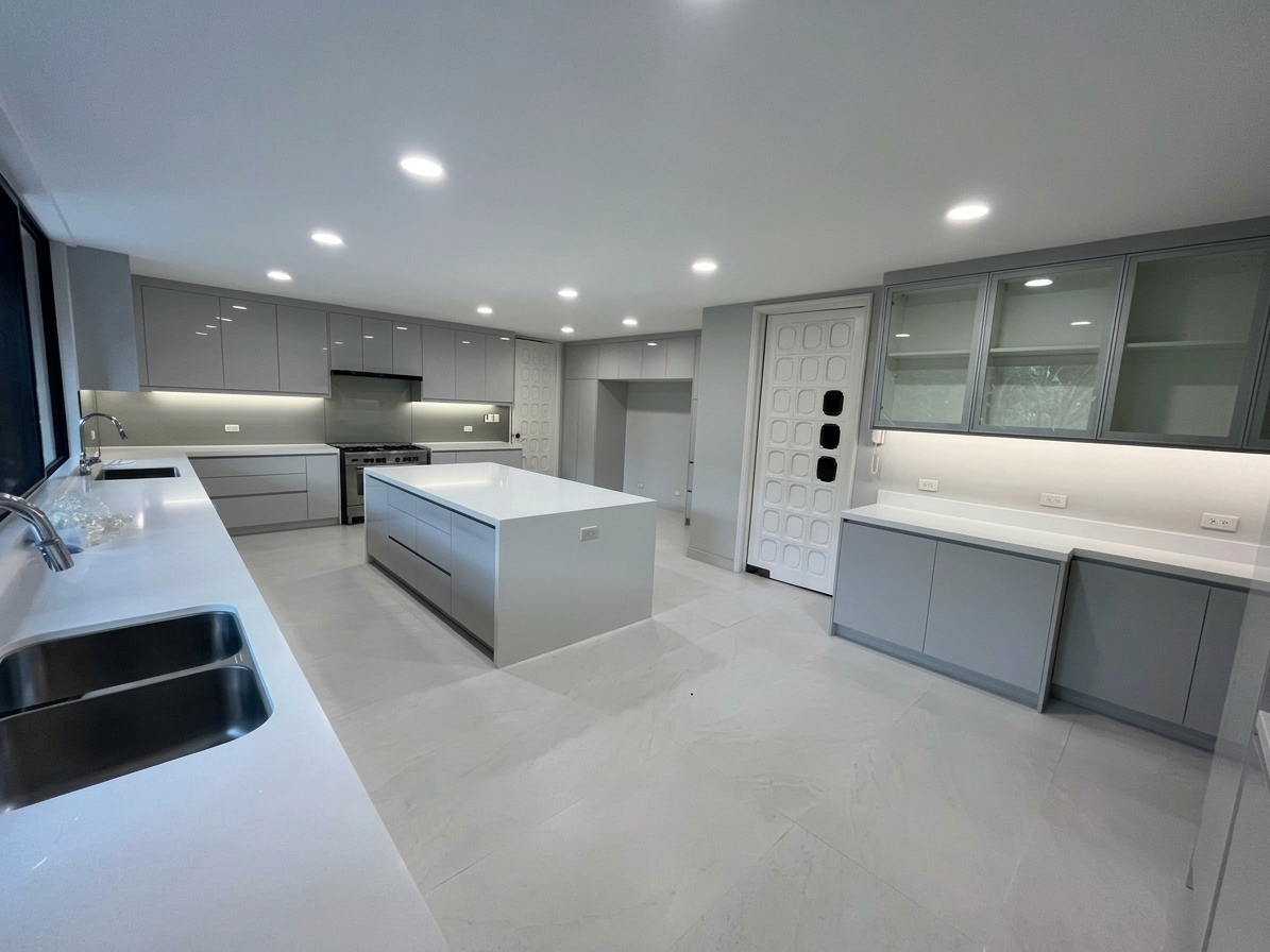Main kitchen with island, full-height cabinetry and stone floors