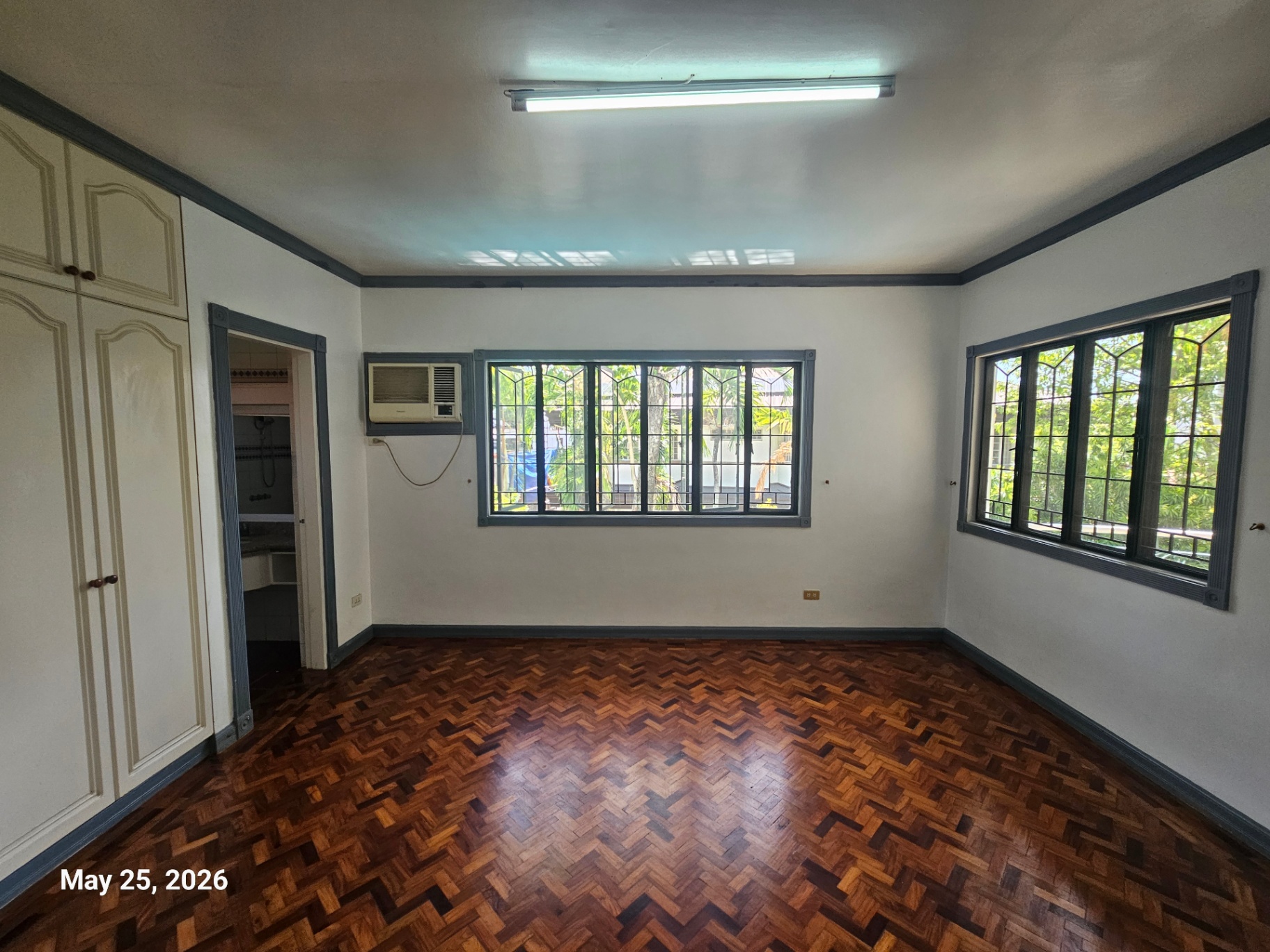 Second bedroom with parquet flooring and garden views