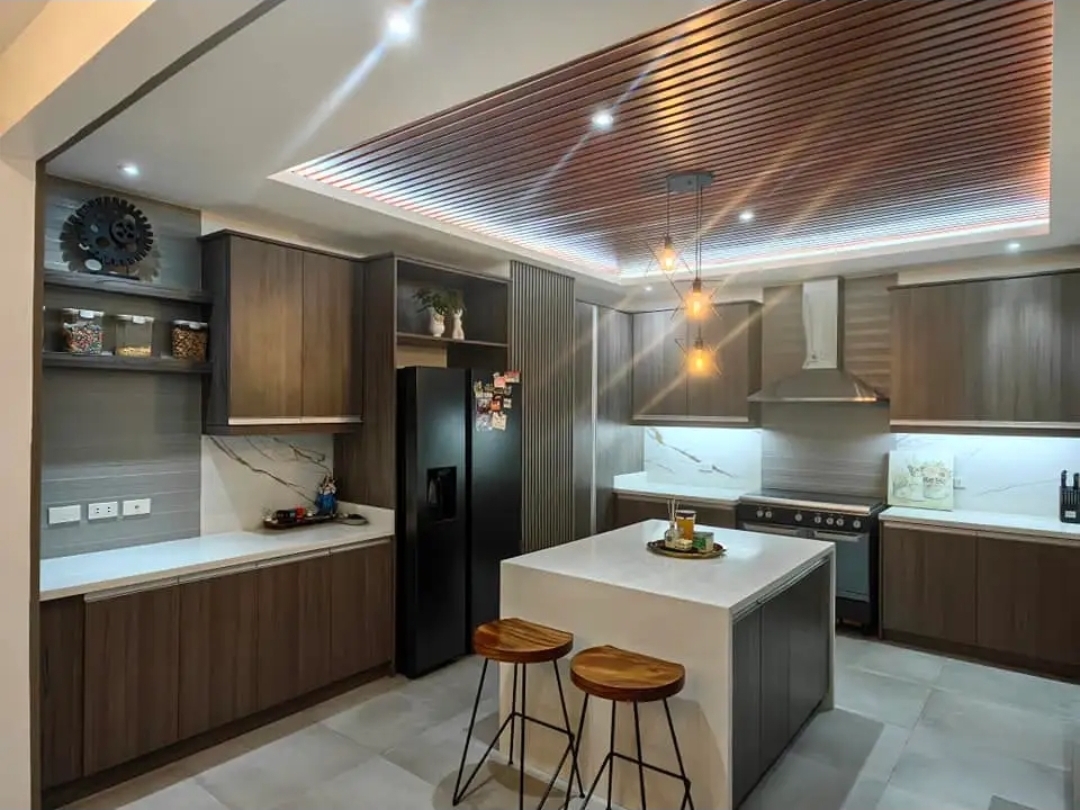 Modern kitchen with island, breakfast bar, and wood-slat ceiling