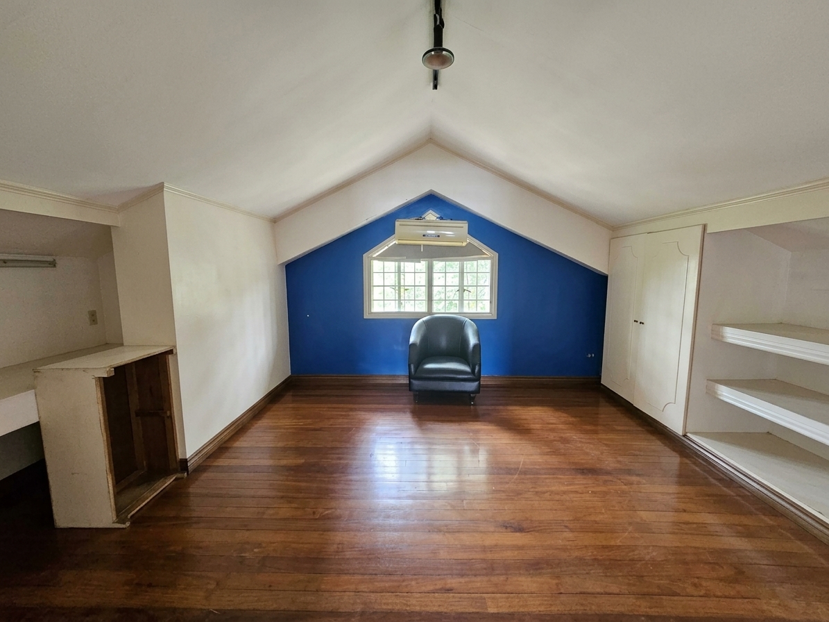 Attic room with pitched ceiling, hardwood floors and blue accent wall