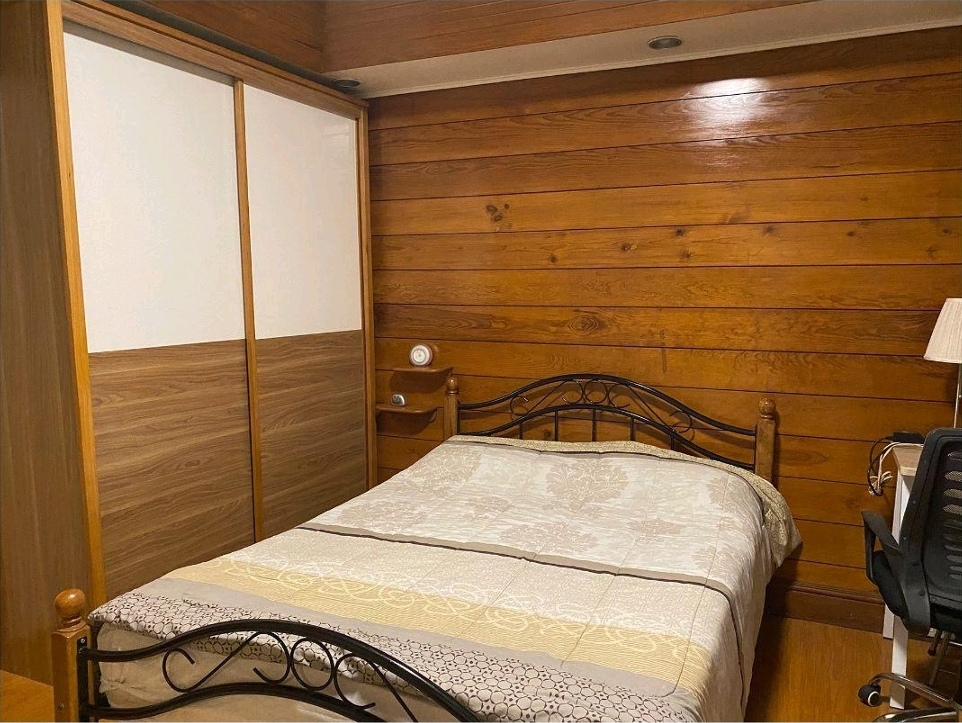 Bedroom with fitted wardrobe and timber wall