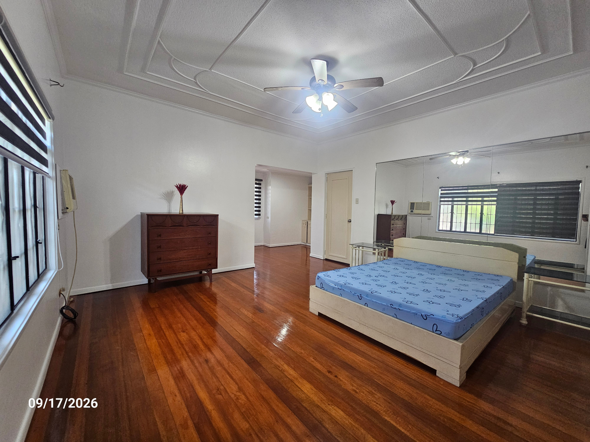 En-suite bedroom with hardwood floors and mirrored wardrobe