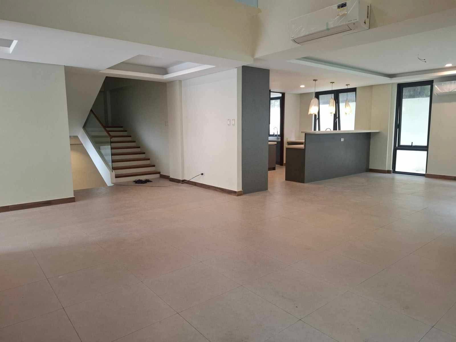 Open living area with staircase and breakfast counter beside the kitchen