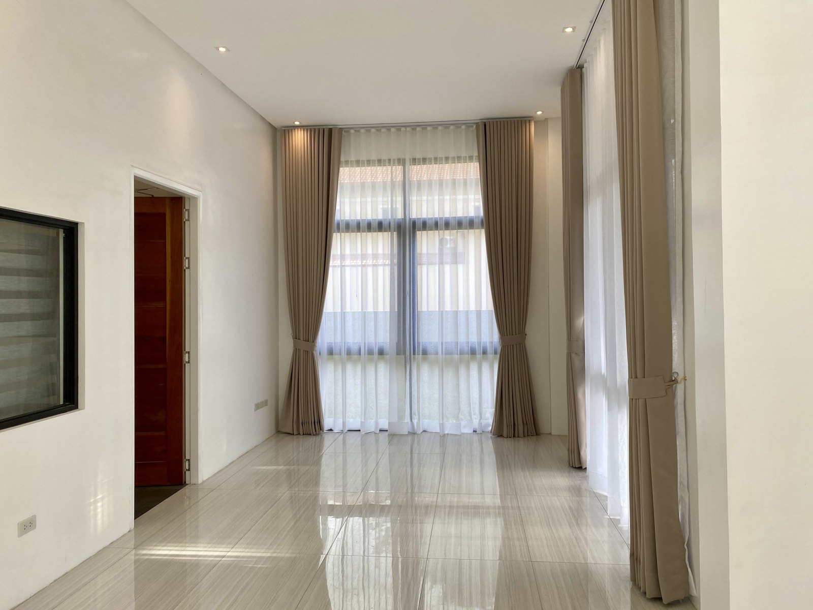 Bright living area with floor-to-ceiling windows and sheer drapes
