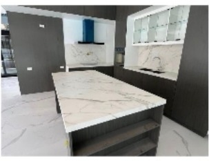 Modern kitchen with marble island, dark cabinetry, and built-in appliances
