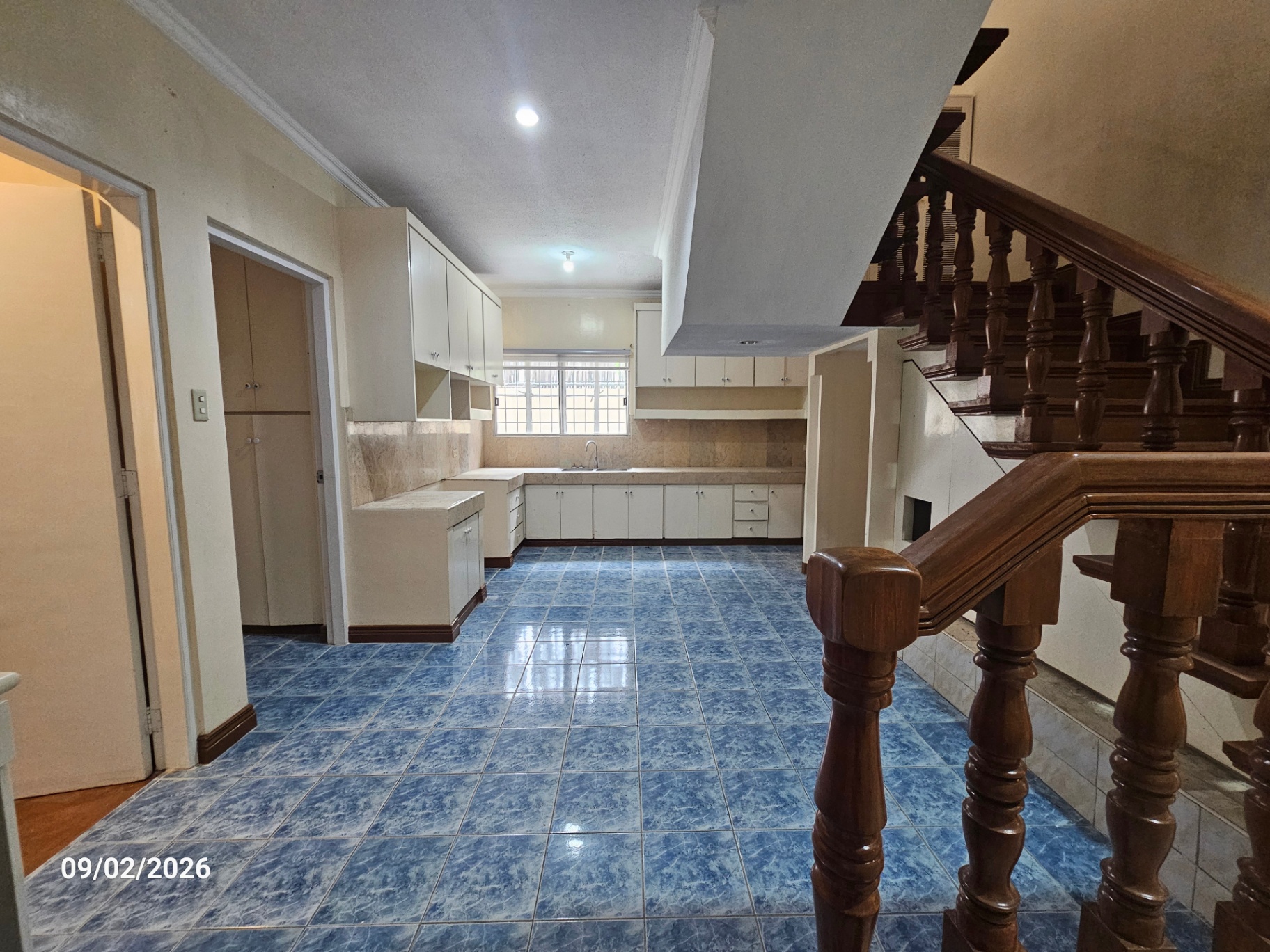 Kitchen with pantry cabinetry, service door and hardwood staircase