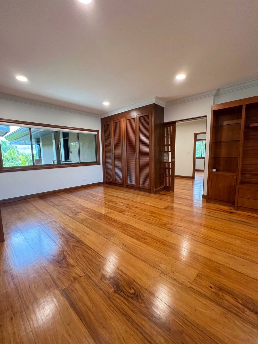 Bedroom with polished hardwood floors and built-ins