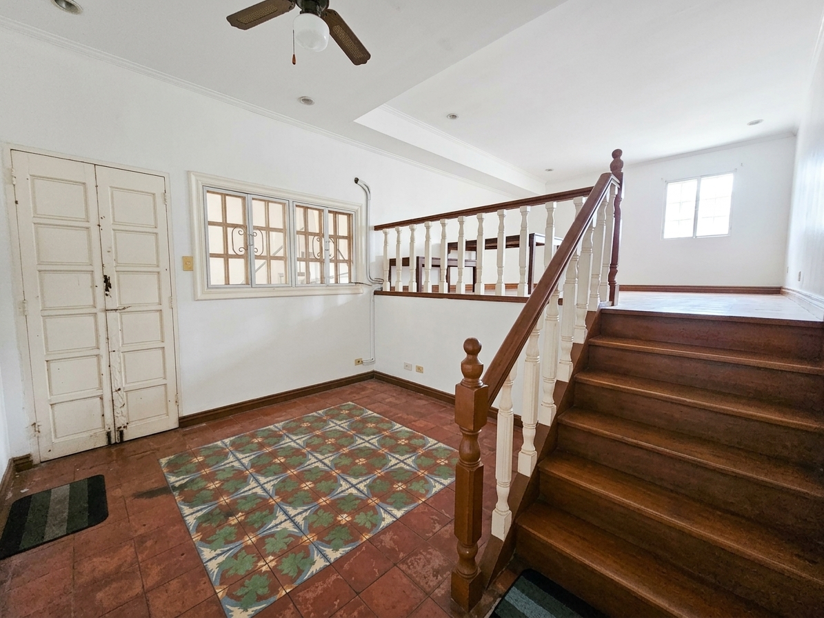Staircase landing with original wood balusters and patterned tile