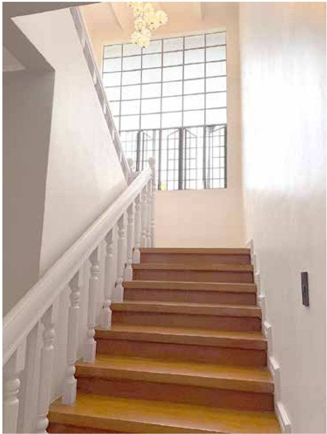 View down the staircase with a decorative chandelier above