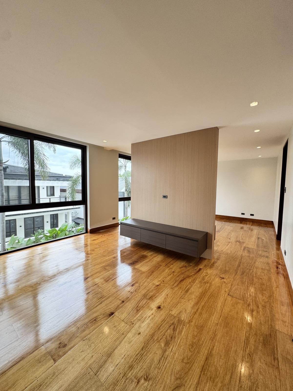 Family room with narra plank flooring and floating media console