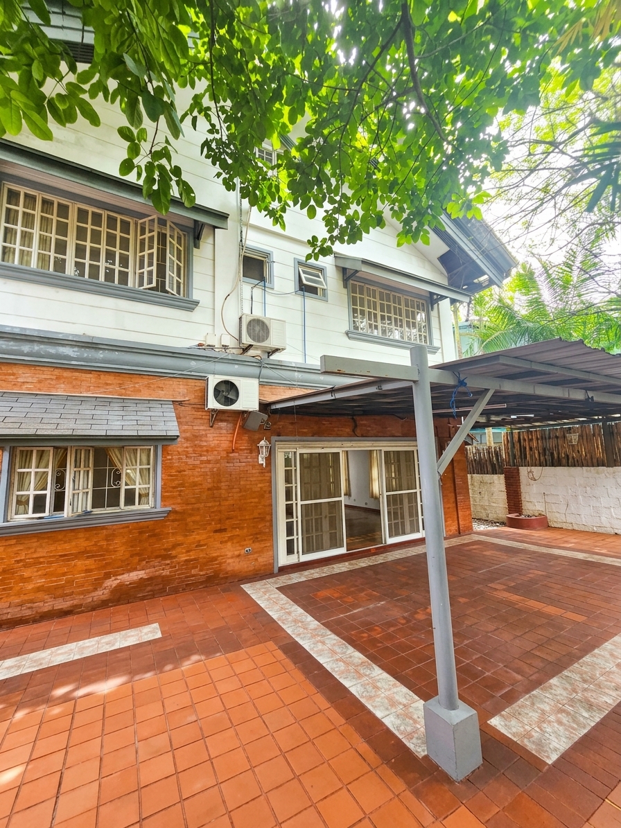 Rear patio and carport with brick flooring and garden views