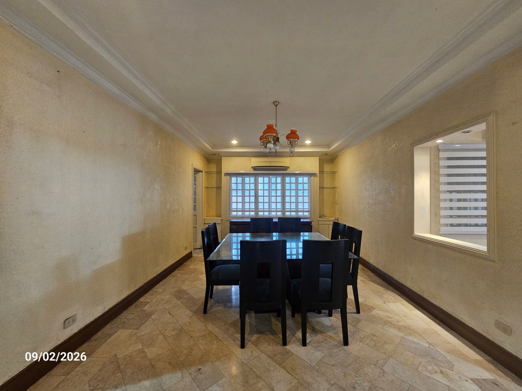 Formal dining room with chandelier, built-in shelving and glass block window
