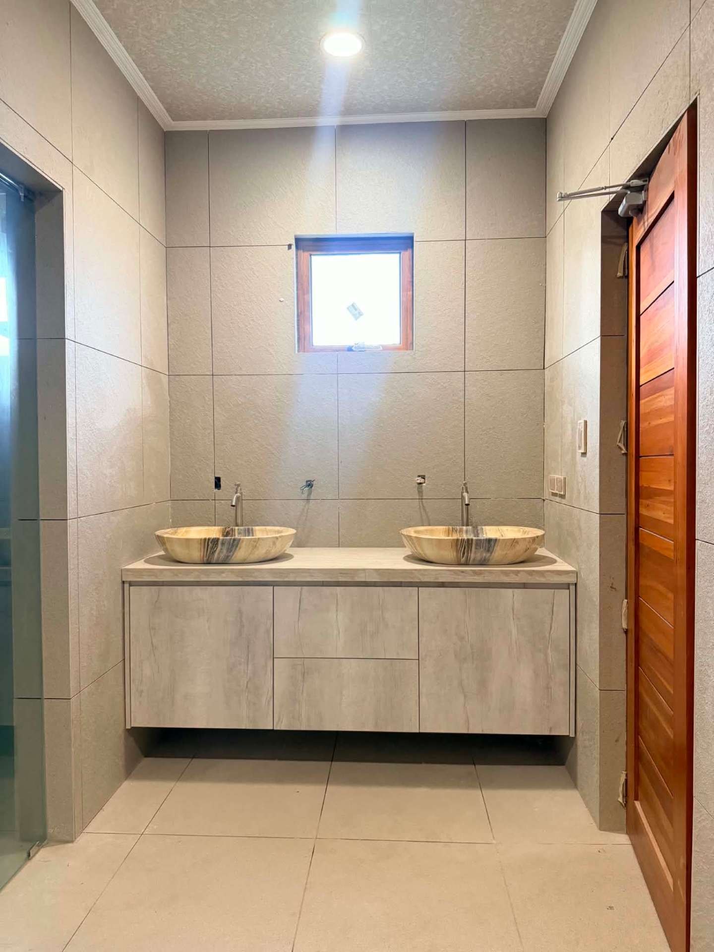 Bathroom with dual stone vessel basins and a floating vanity