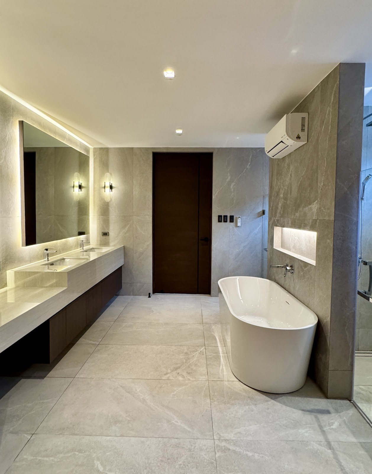 Master bath with twin vanities, freestanding tub and stone cladding