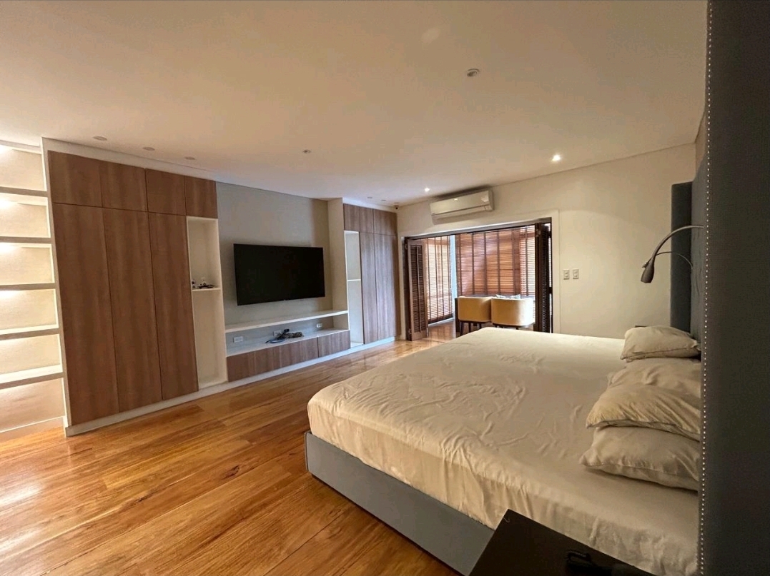 En-suite bedroom with built-in wardrobes and wall-mounted TV