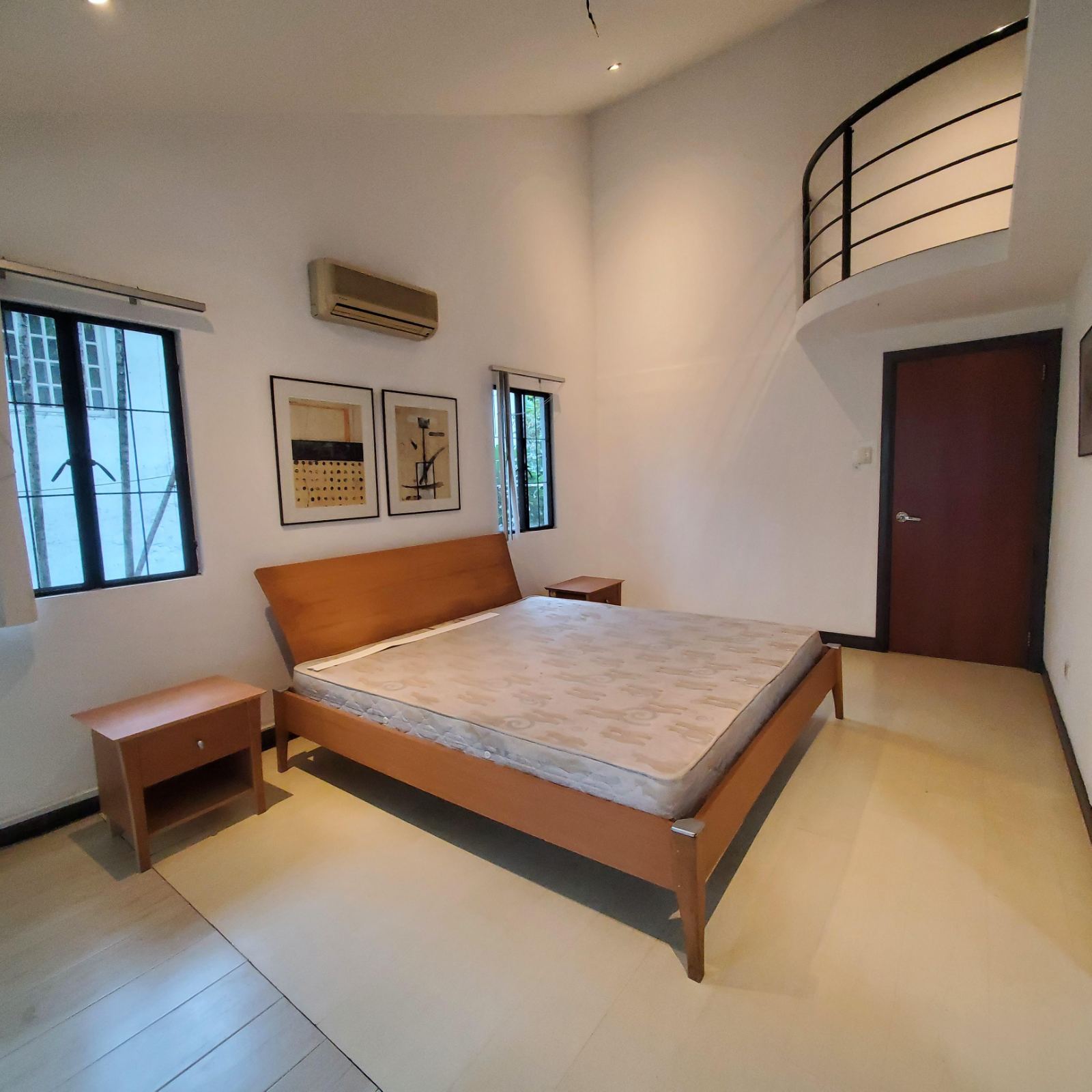 Bedroom with high ceiling and curved mezzanine balcony