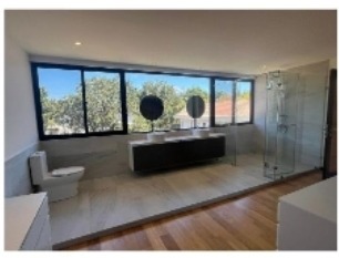 Master bathroom with double vanity, walk-in shower, and wide window