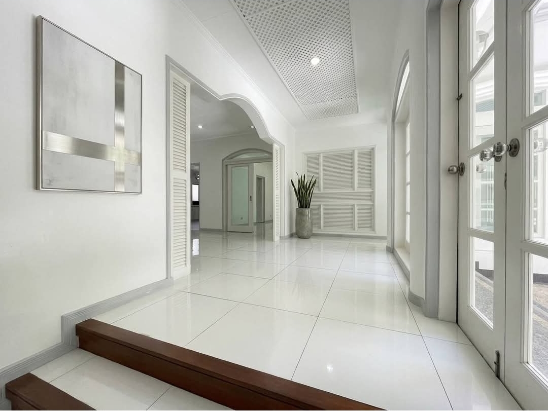 Entry foyer with hardwood steps and tall glazed doors