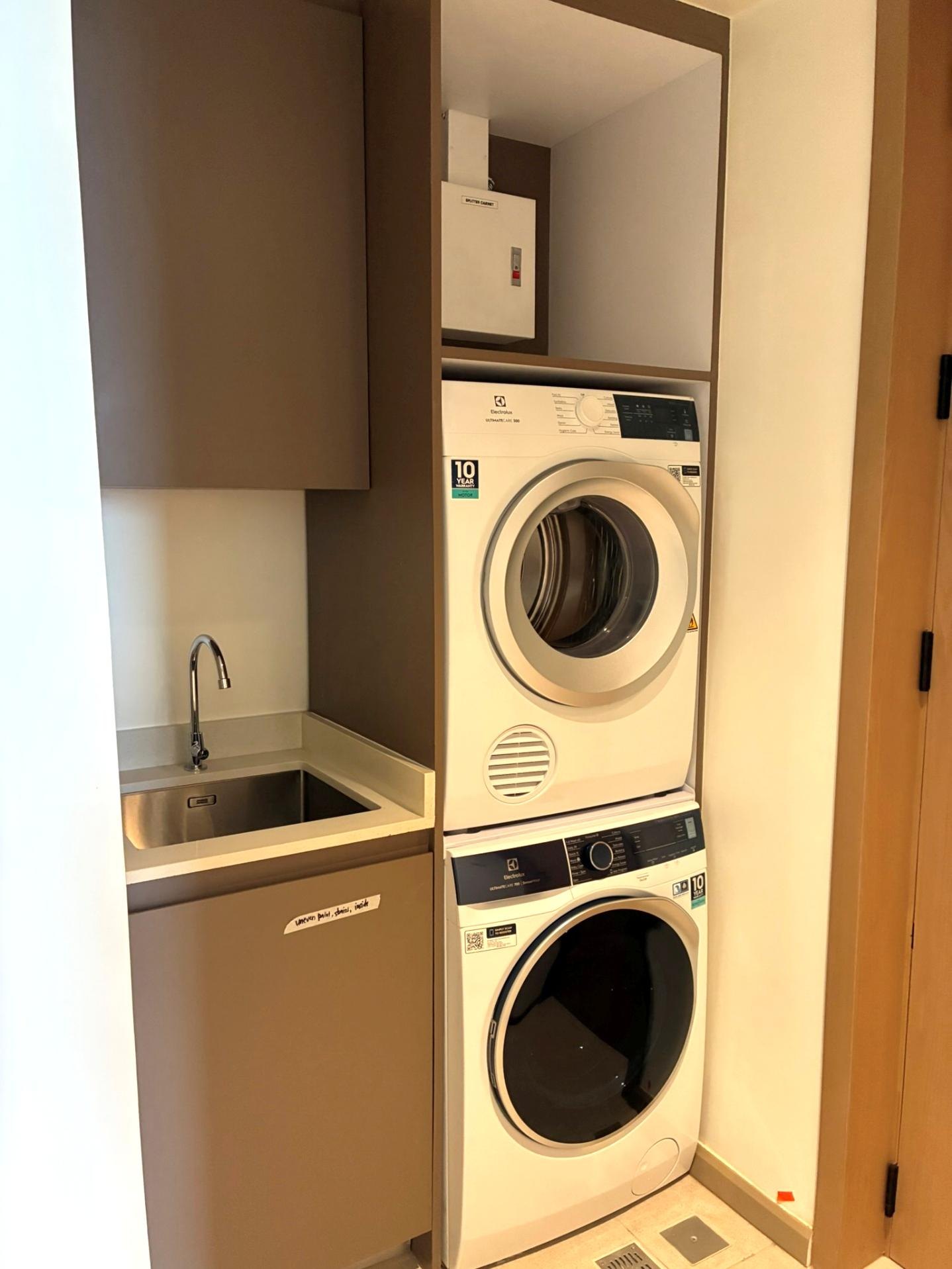 Laundry area with sink and stacked washer and dryer