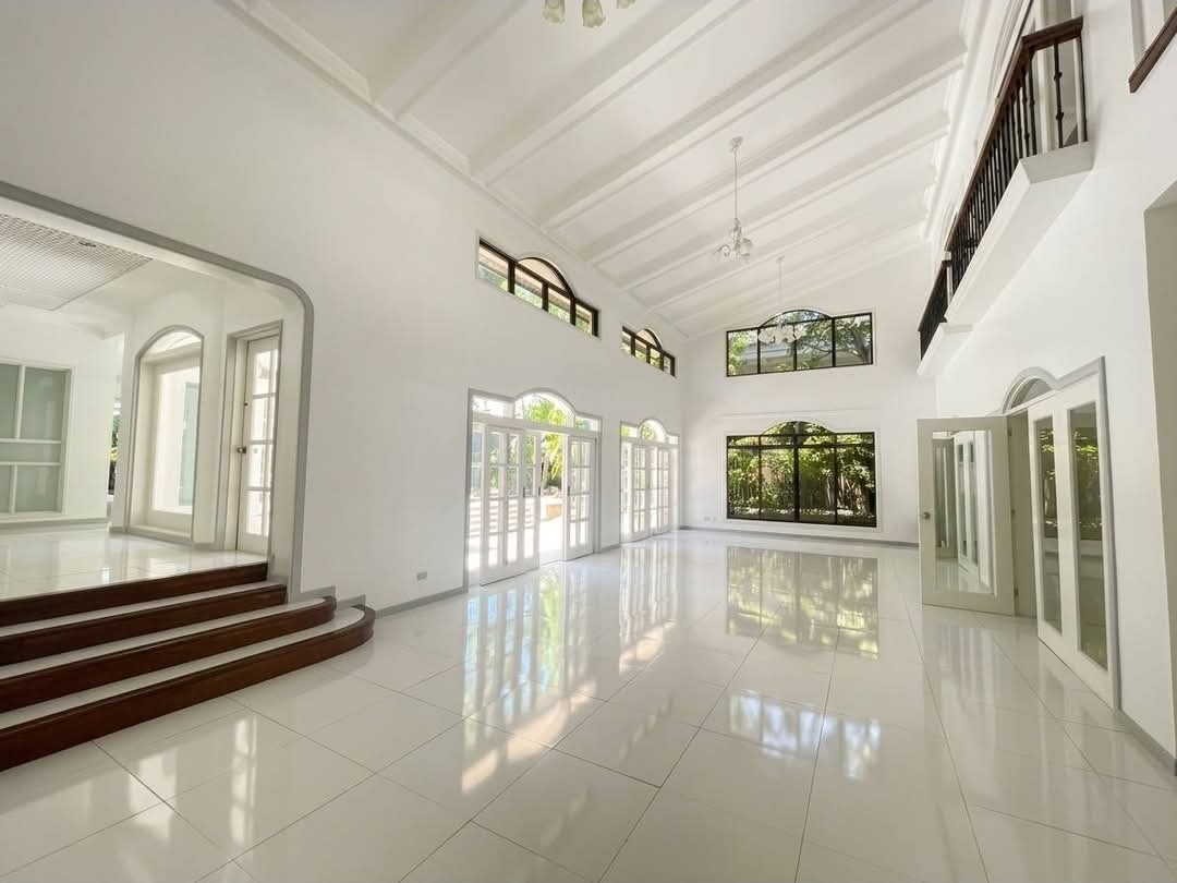 Formal living room with vaulted beamed ceiling and arched windows