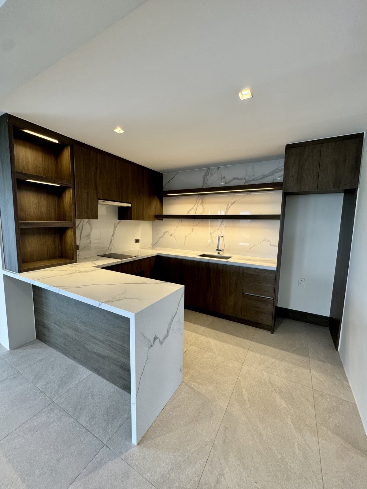 Third-floor kitchenette in dark timber with marble backsplash