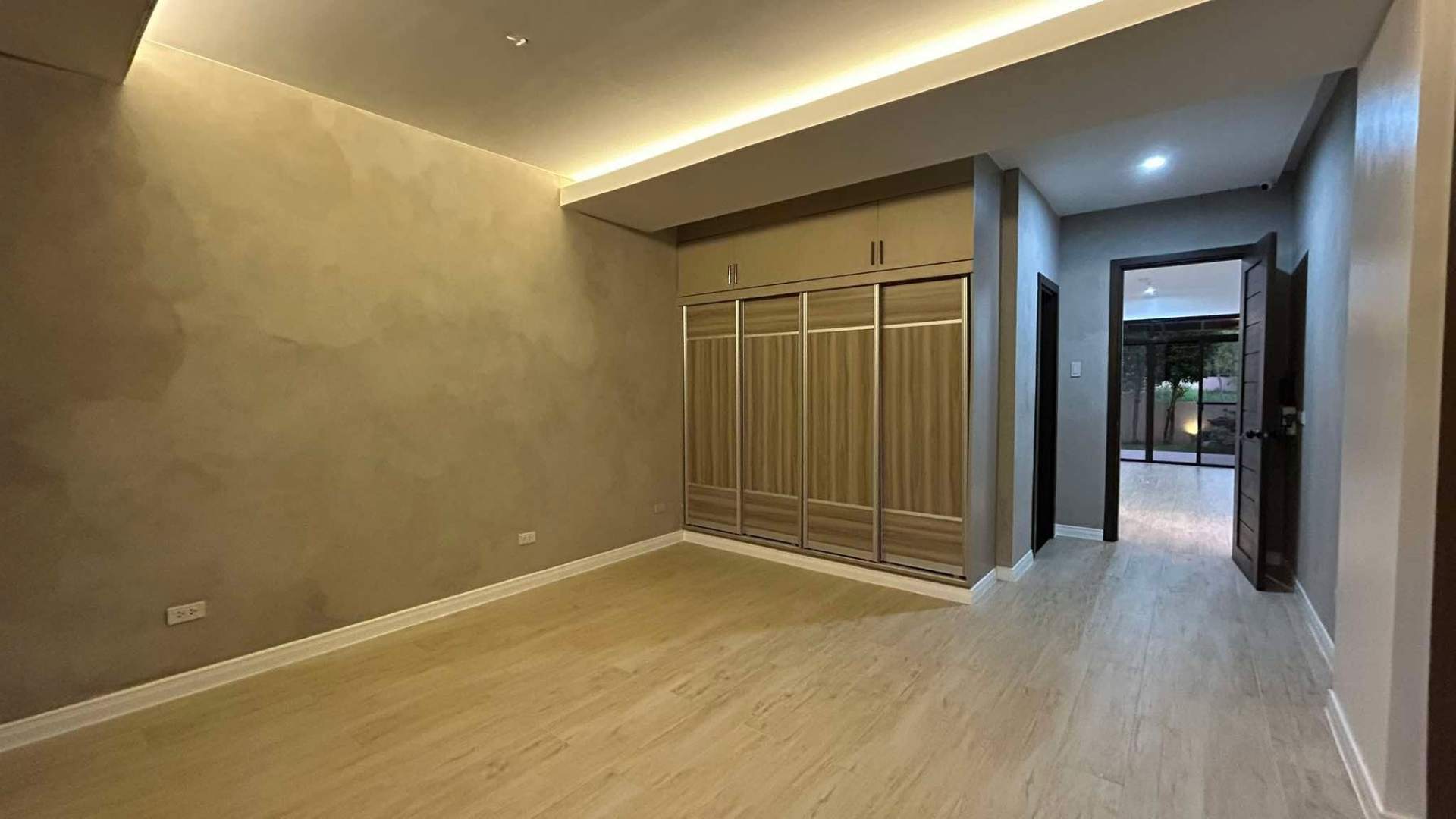 Bedroom with fitted wardrobes and warm cove lighting