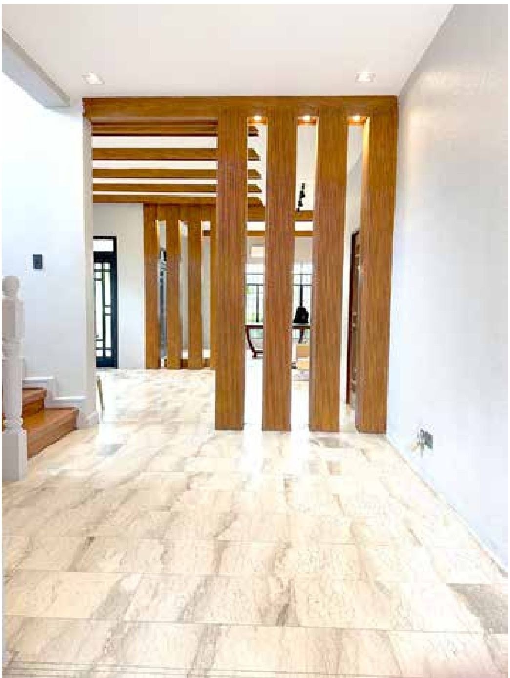 Entrance foyer with dark door frame and marble flooring