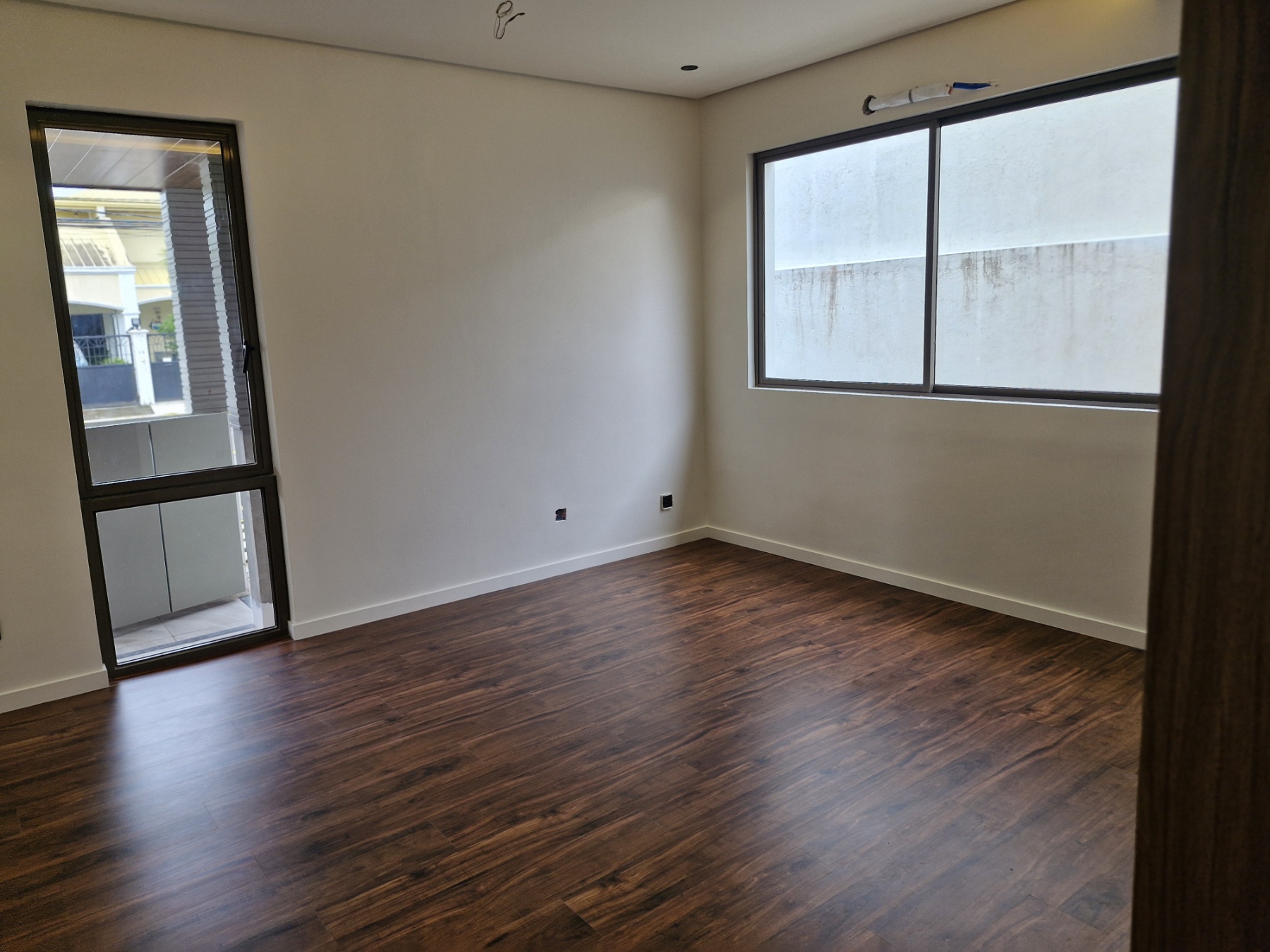 Bedroom with wood flooring and large windows