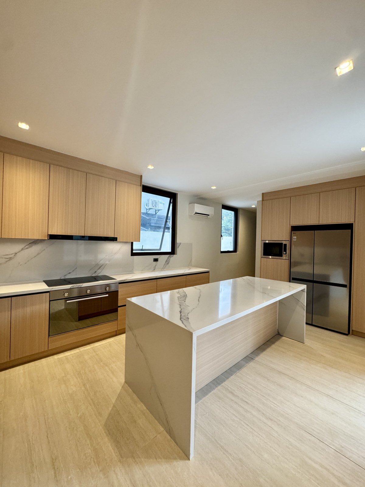 Main kitchen with marble island, oven and full-height cabinetry
