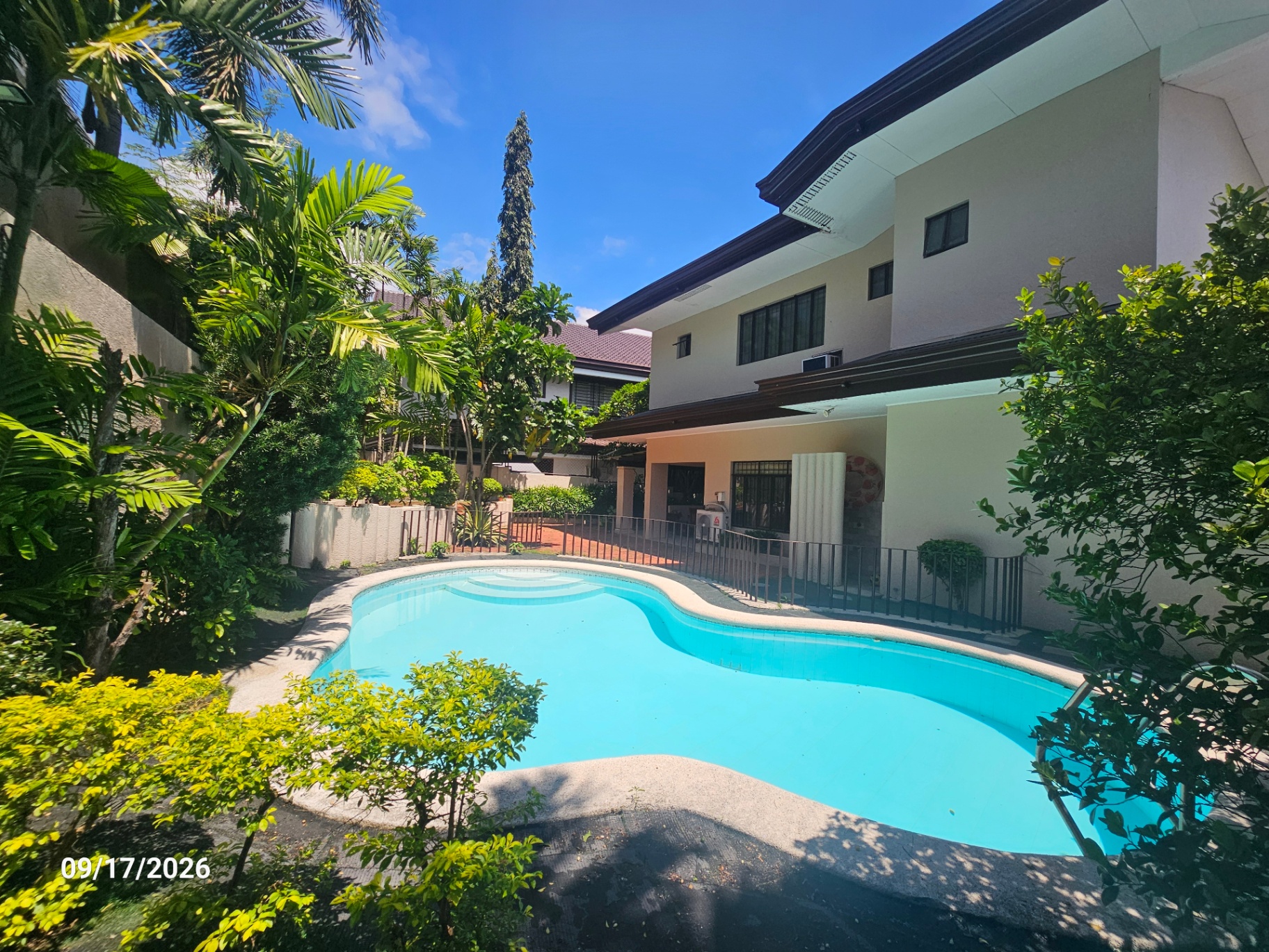 Swimming pool and garden under open blue skies