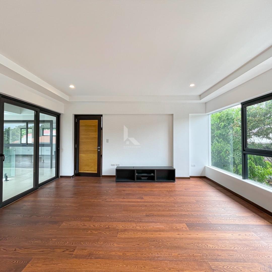 Bedroom with hardwood floors, corner windows, and balcony access