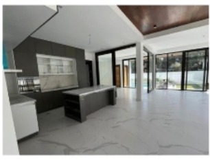 Open living area with high ceilings and sliding glass doors to the garden
