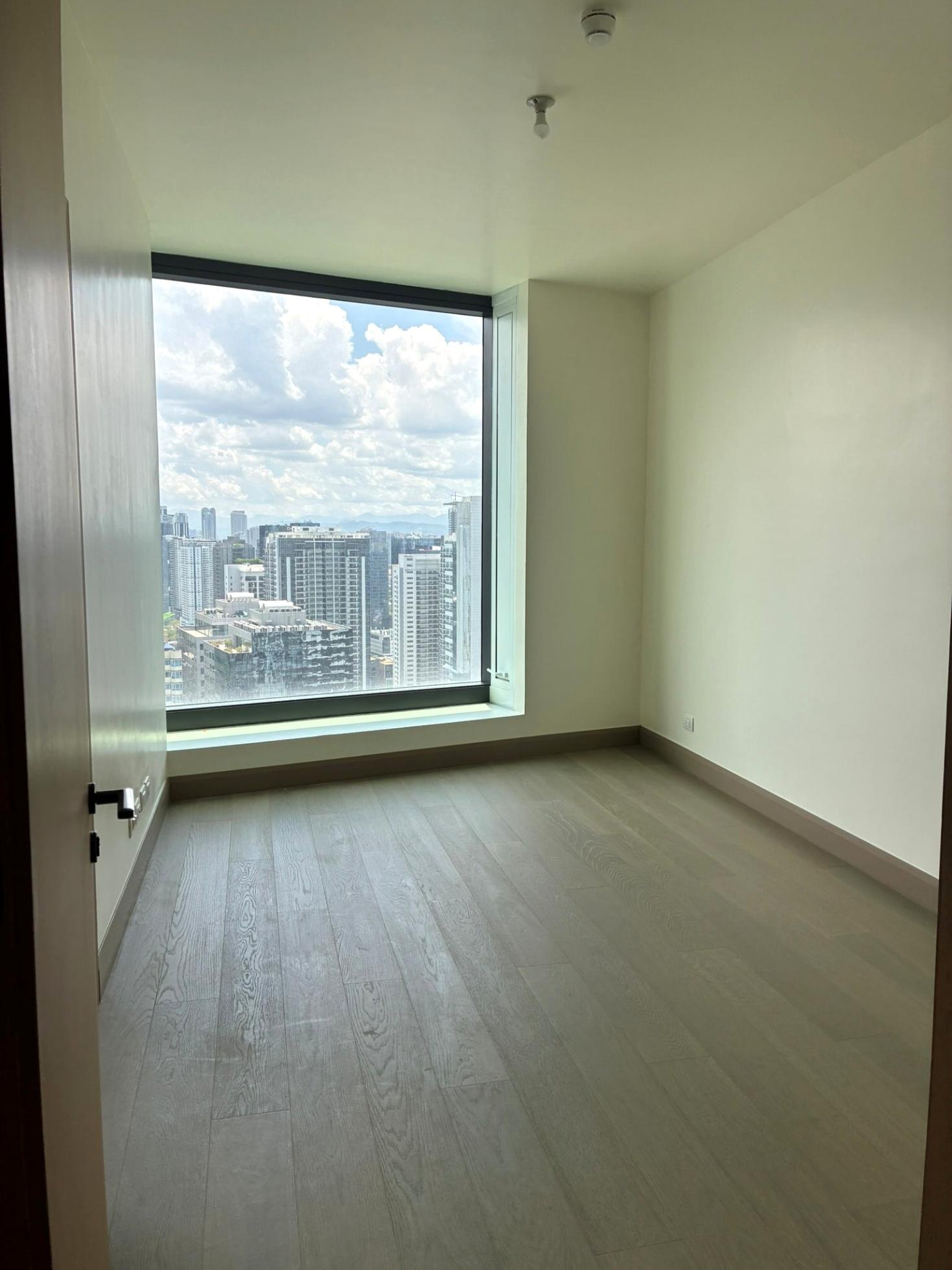 Second bedroom with a large window facing the skyline