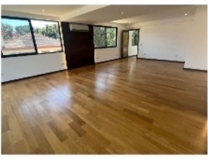 Master bedroom with hardwood floors and large garden-facing windows