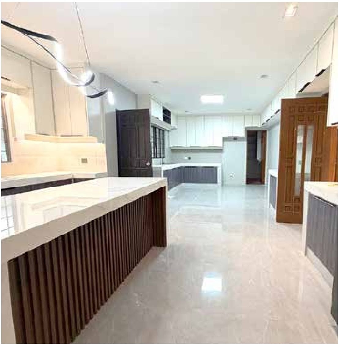 Kitchen area with white and charcoal cabinetry and central island