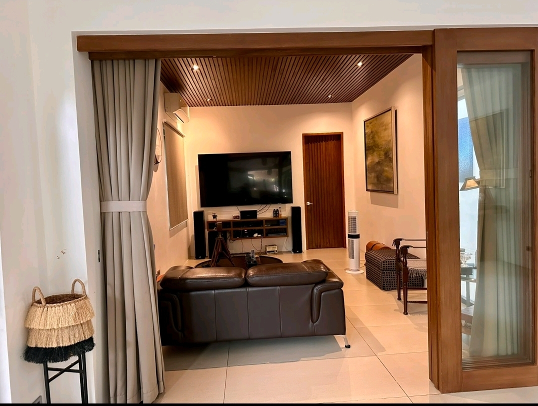 Media den with slatted timber ceiling, leather sofa and wall-mounted television