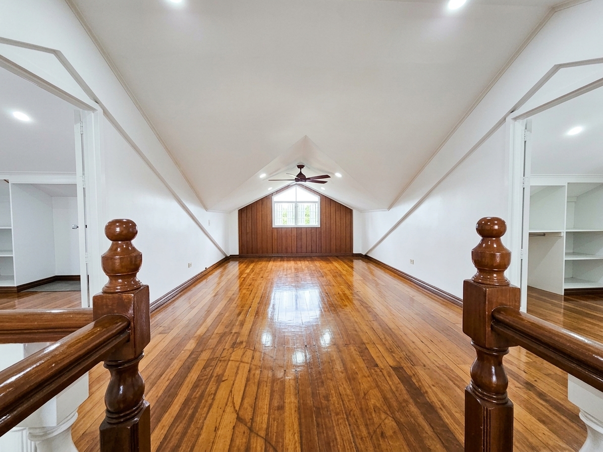 Spacious attic hall with pitched ceiling and built-in shelving