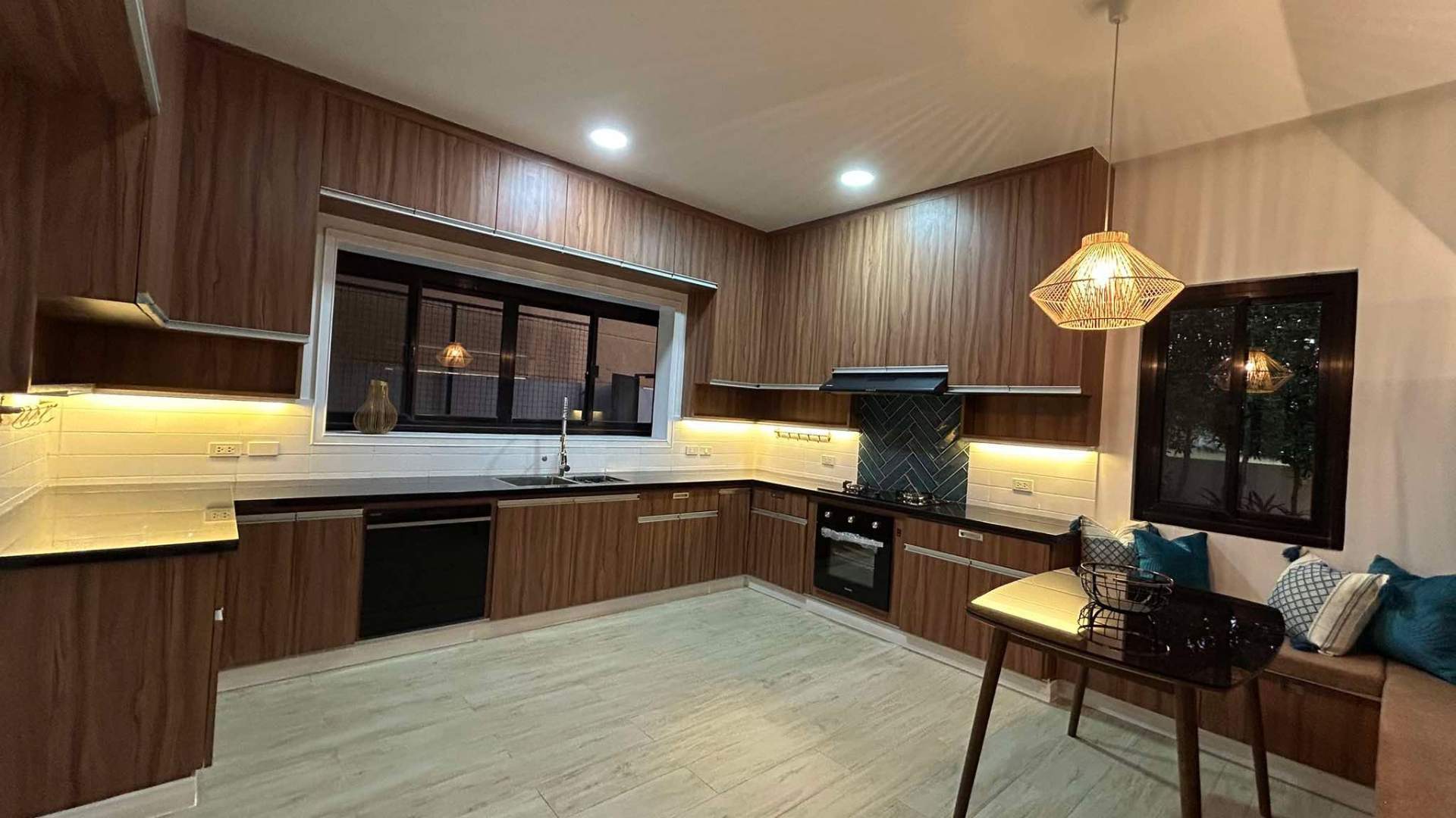 Gourmet kitchen in walnut cabinetry with herringbone backsplash