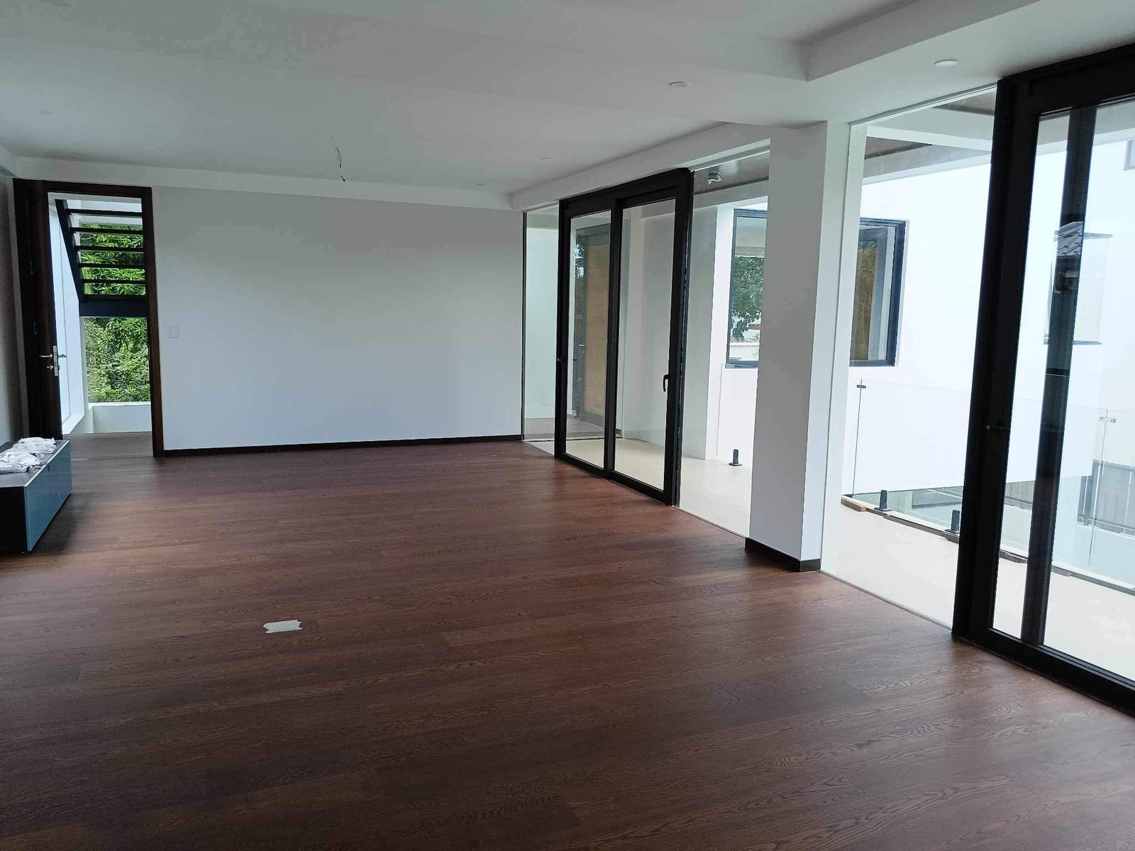 Upper-floor living area with wide plank hardwood floors and sliding glass doors