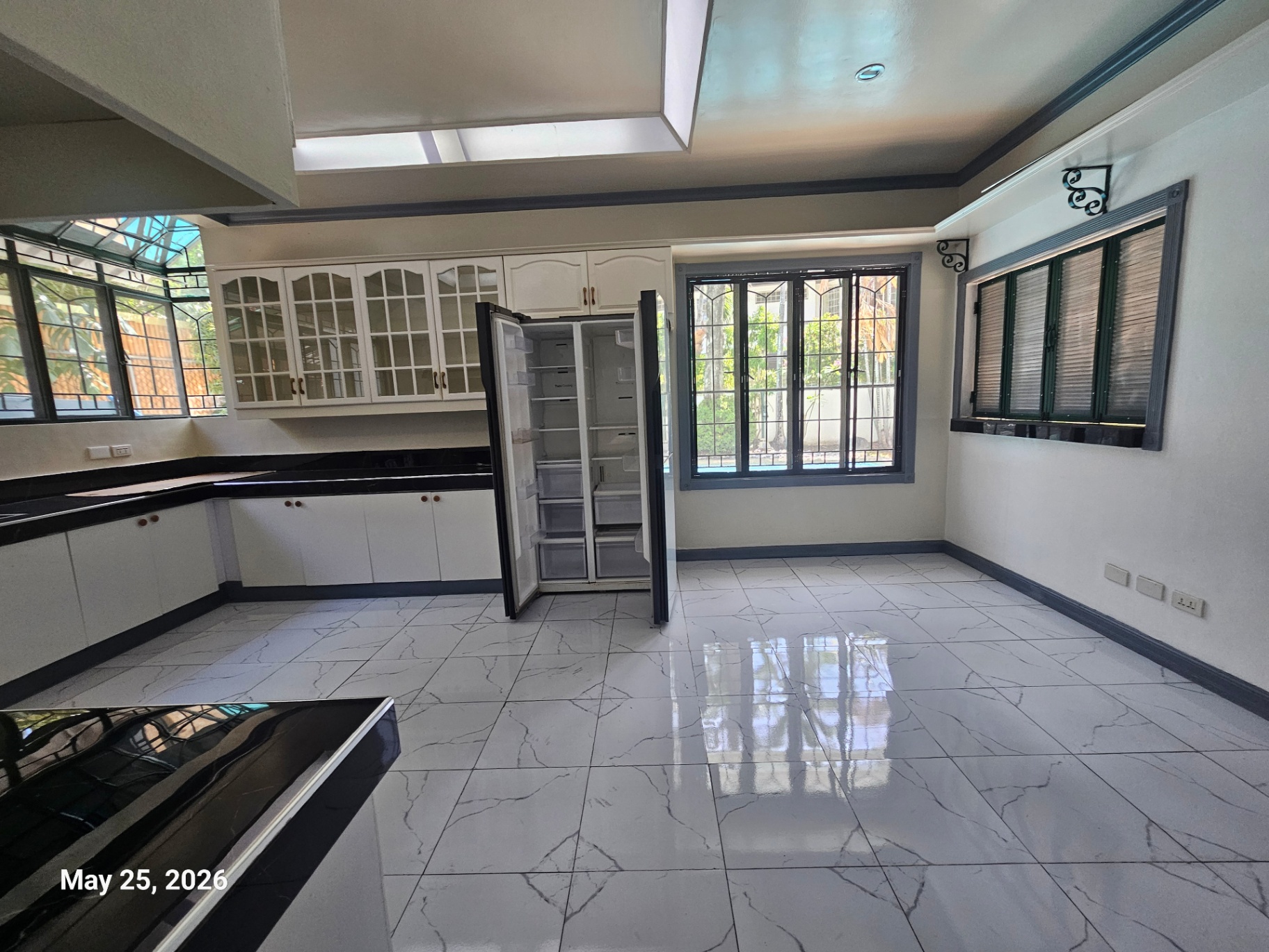 Second kitchen area with glass-front cabinetry and garden windows