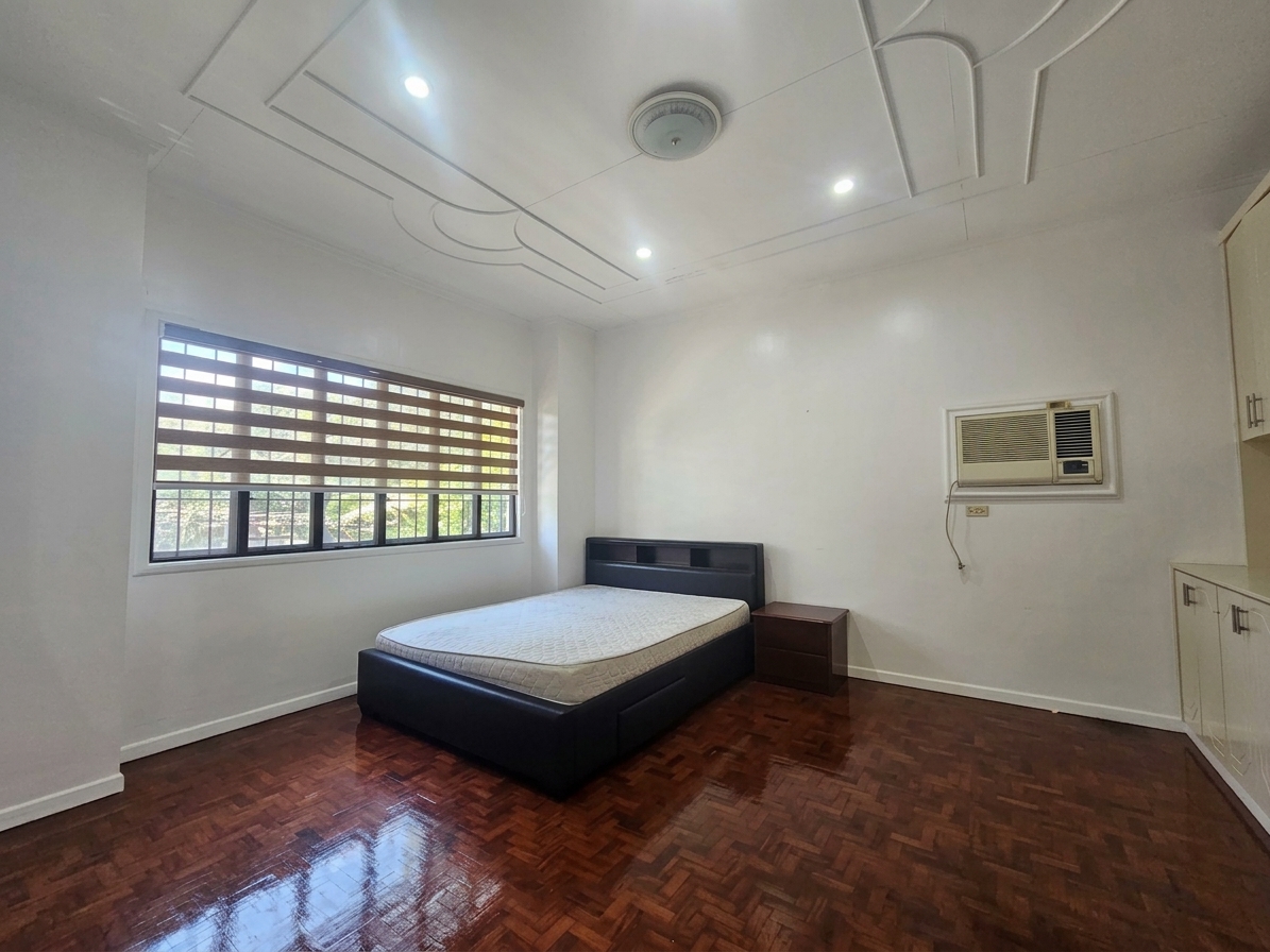 Bedroom with wood parquet flooring and window blinds