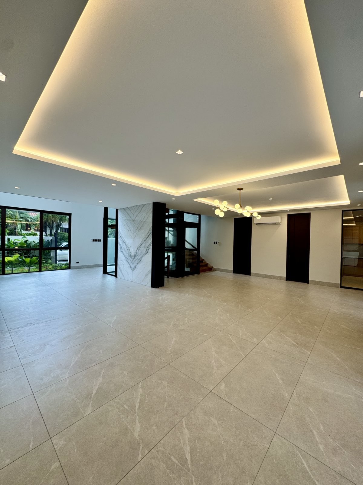 Formal living and dining hall with cove lighting and glass elevator