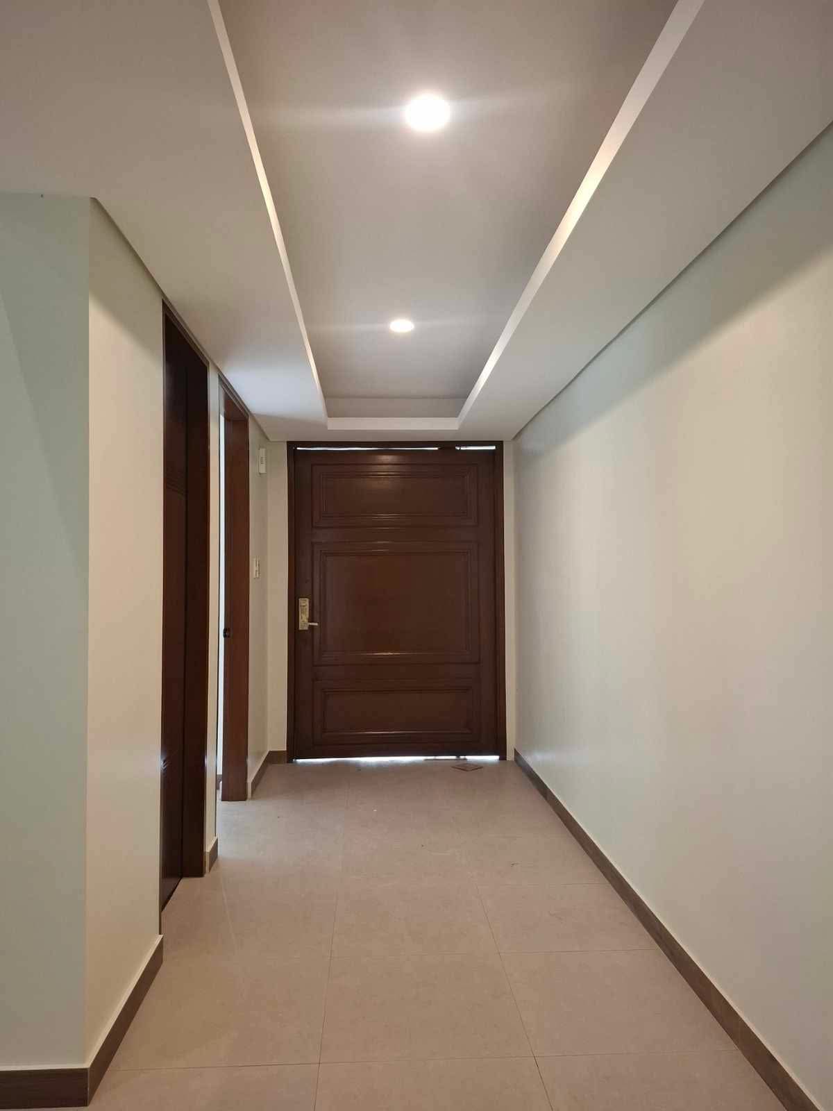 Entrance hallway with cove lighting leading to a solid wood main door