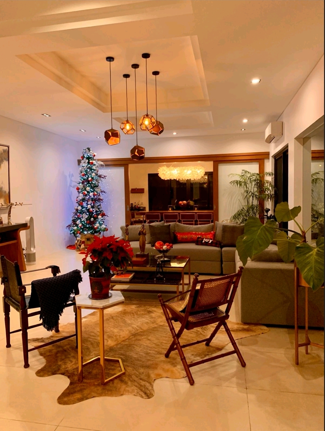 Living area at night with coffered ceiling, sculptural pendants and glass sliding doors