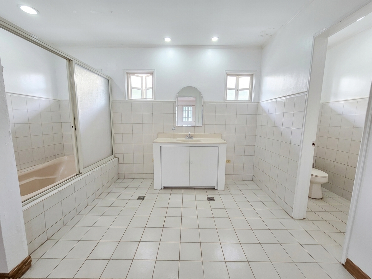 Family bathroom with tiled walls, tub and vanity