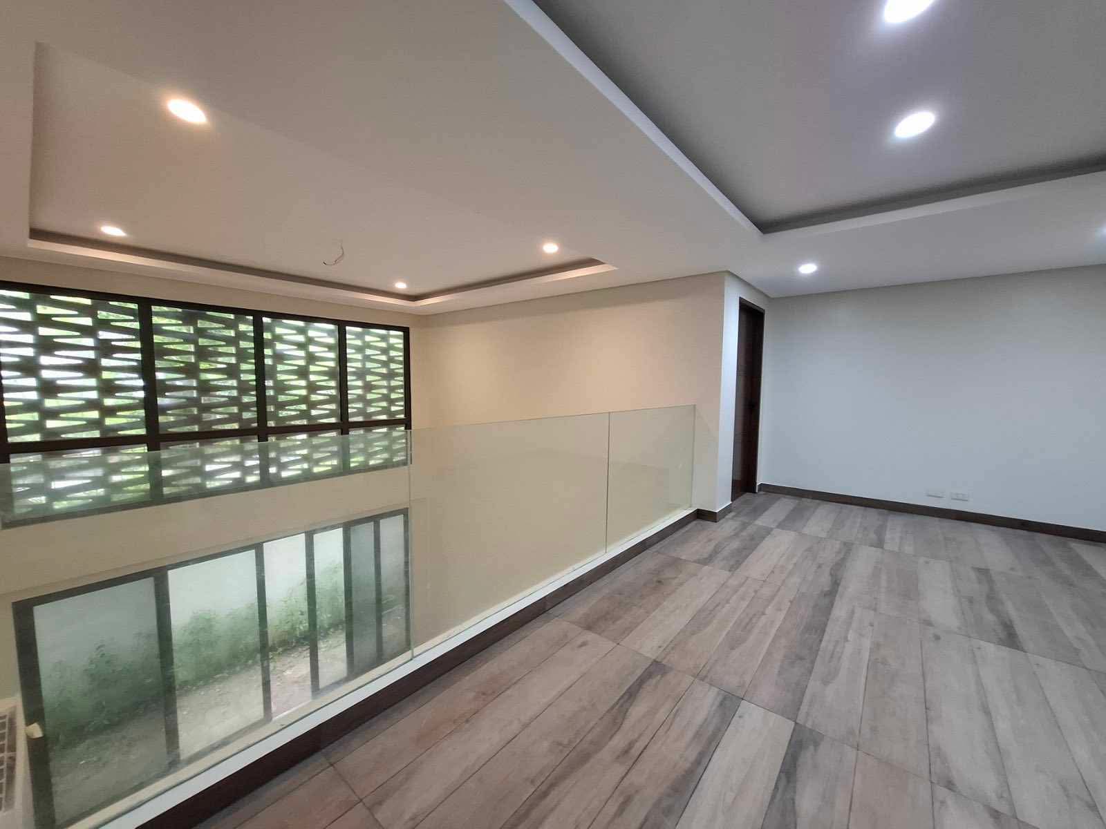 Upper landing with glass balustrade beside the breeze-block screen wall