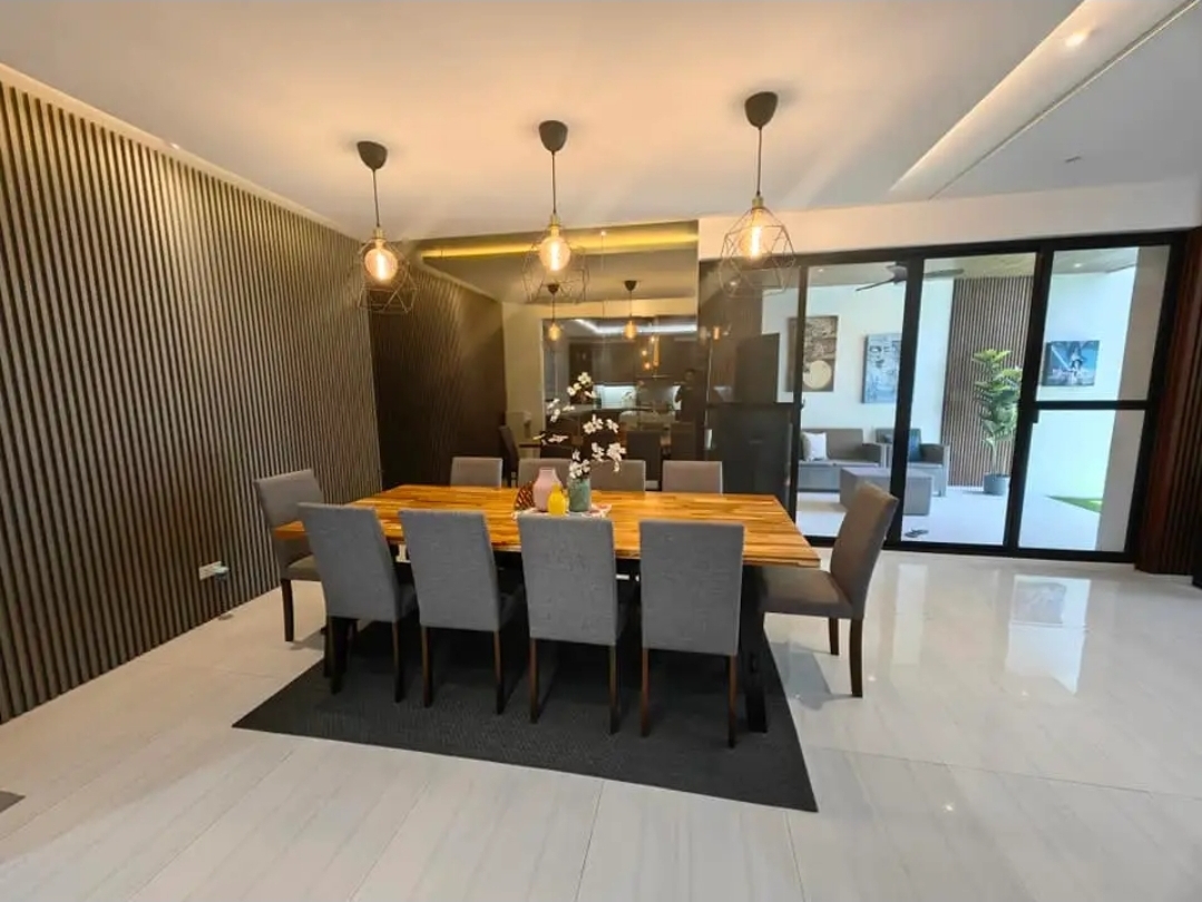 Formal dining area with pendant lighting and wood-slat wall
