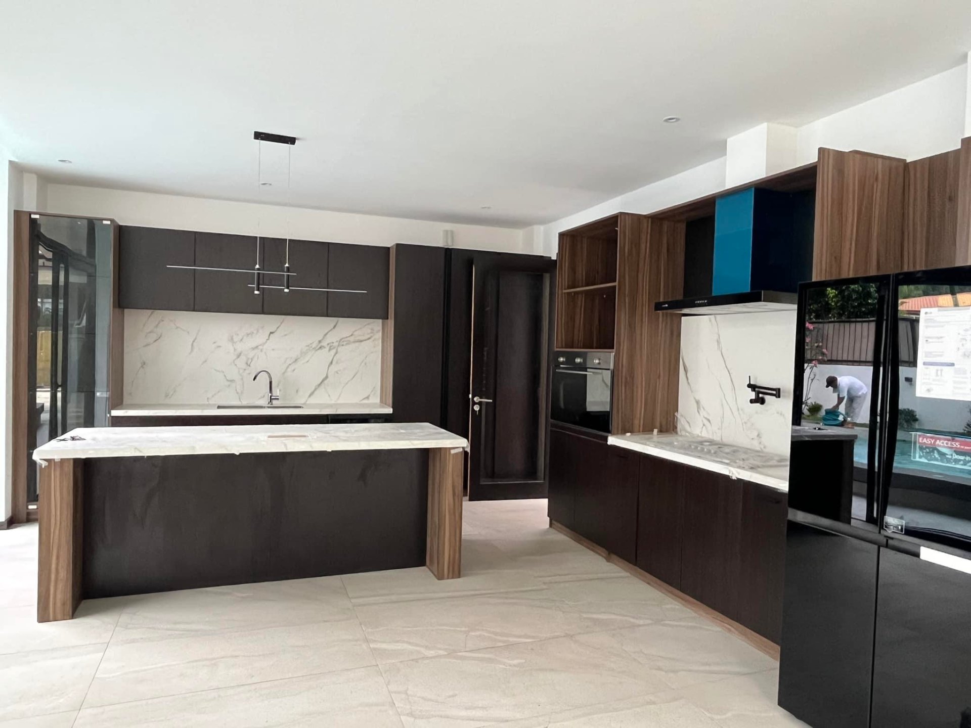 Open-plan fully equipped kitchen with stone island and built-in appliances